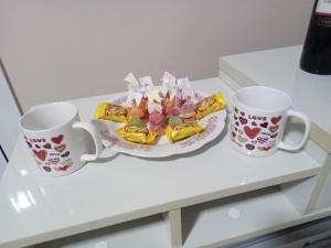 zwei Tassen und ein Teller Essen auf dem Tisch. in der Unterkunft Suíte Master in Frederico Westphalen