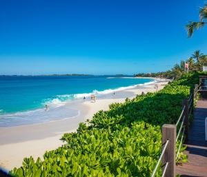 a beach with people on the sand and the ocean at Paradise Island Beach Club in Creek Village +79 photos