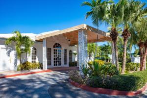 a house with palm trees in front of it at Paradise Island Beach Club in Creek Village