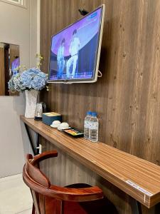 a television on a wooden wall with a wooden table at BeSea Hotel in Danang