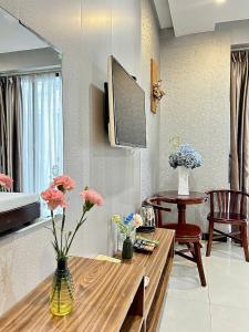 a living room with a table with flowers on it at BeSea Hotel in Danang