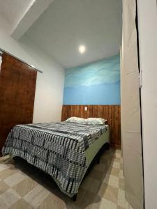 a bedroom with a bed and a blue wall at PouCasa Pousada in Araruama +11 photos