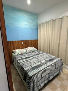 a bedroom with a bed and a painting on the wall at PouCasa Pousada in Araruama