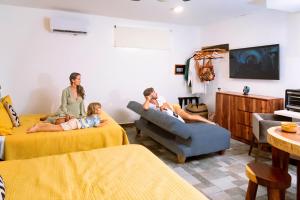 una famiglia seduta sui letti in un soggiorno di Villa Kiin con piscina privada a 300 metros del mar a Playa del Carmen