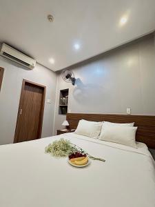 a white bed with a plate of food on it at BeSea Hotel in Danang