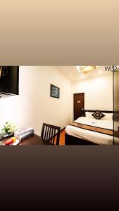 a bedroom with a bed and a desk with a table at Wild LoTus Ha Noi in Hanoi