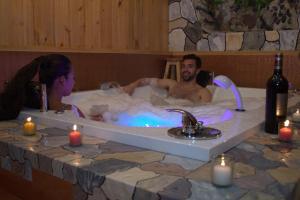 a man and a woman in a bath tub with candles at Casa Mujer Villa Agueda in Chocontá
