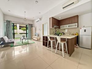 a kitchen with a refrigerator and a counter top at Trifirah Homestay in Kota Kinabalu