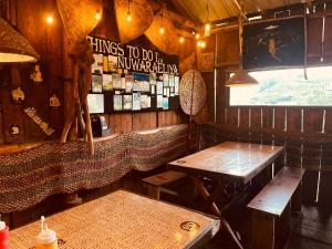 a restaurant with a table and benches in a room at Ambula Resort in Nuwara Eliya