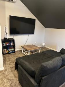 a living room with a couch and a flat screen tv at The Pit Stop Clarksville Rest Easy in Clarksville