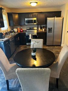 a kitchen with a table and chairs and a refrigerator at The Pit Stop Clarksville Rest Easy in Clarksville