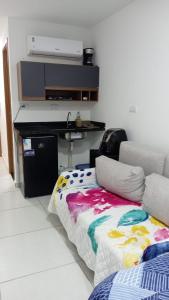 un soggiorno con un divano e un letto di Flat Sol e Mar Residence Porto de Galinhas PE a Porto De Galinhas