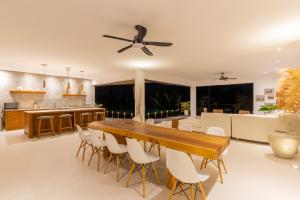 a dining room with a large wooden table and white chairs at IBU The Sanctuary by OXO in Ubud