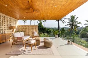 a living room with a large wooden ceiling at IBU The Sanctuary by OXO in Ubud