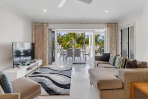salon z kanapą i telewizorem w obiekcie Gris at Island Views—Pool Paradise on the Beach w mieście Palm Cove