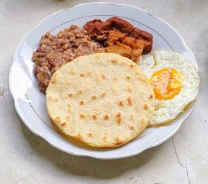 a plate of breakfast food with eggs bacon and beans at Hostal Rojoyale capurgana in Acanti