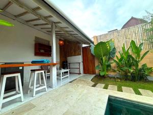 una cocina al aire libre con bar y parrilla en D'Gilian Bungalow, en Gili Trawangan