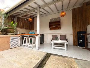 Una cocina al aire libre con taburetes blancos y un mostrador. en D'Gilian Bungalow, en Gili Trawangan