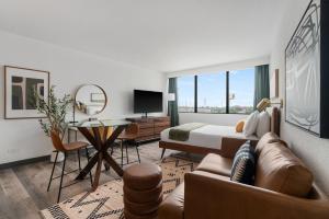 um quarto com uma cama e uma sala de estar com um sofá em Lodgeur Upper Kirby, Houston - Close to Greenway Plaza, Galleria, Montrose em Houston