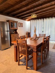 a kitchen with a wooden table with chairs and a refrigerator at Cabana Charmosa - Refúgio dos Plátanos in Rancho Queimado +26 photos