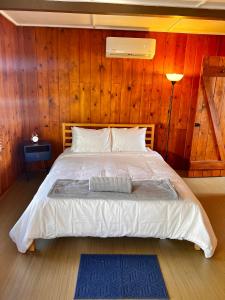 Joshua Tree Ranch House Motel - Downtown - Room #3 في جوشوا تري: غرفة نوم بها سرير وجدار خشبي