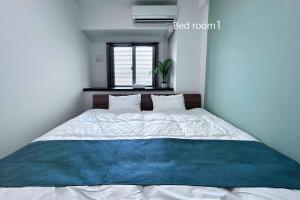 ein Schlafzimmer mit einem weißen Bett mit einer blauen Decke in der Unterkunft YAKA Ocean Beach Resort in Yaka