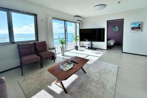 ein Wohnzimmer mit Tisch und Stühlen und einem Fernseher in der Unterkunft YAKA Ocean Beach Resort in Yaka