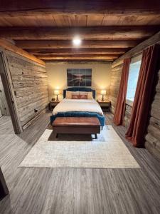 a bedroom with a bed in a room with wooden walls at A Novel Stay 3 bed 2 bath log cabin in Shelbyville, IL in Shelbyville