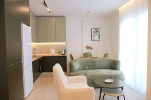 a living room with a chair and a table and a kitchen at HORIZONT Premium Apart-Hotel in Shkodër