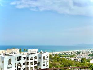 a white apartment building with the ocean in the background at Coastal Elegance - Bella Vista in Cabo Negro