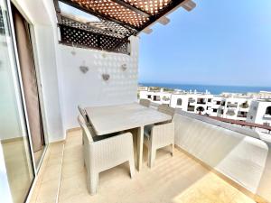 a table and chairs on a balcony with the ocean at Coastal Elegance - Bella Vista in Cabo Negro