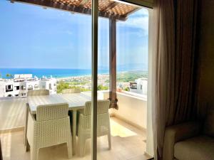a table and chairs on a balcony with a view of the ocean at Coastal Elegance - Bella Vista in Cabo Negro +37 photos