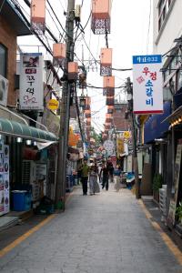 a street in an asian city with people walking down the street at Staymuk Seochon, Center of Seoul in Seoul