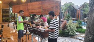 a group of people preparing food on a grill at Trang An Green Bungalow & Restaurant in Ninh Binh