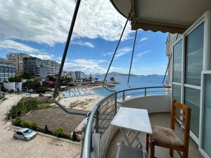 a balcony with a table and a view of the ocean at ALPHA SEASIDE Apartment in Sarandë