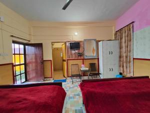 a room with two chairs and a tv on a wall at Himvadi Resort in Kausani