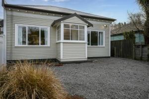 une petite maison avec un cimetière devant elle dans l'établissement Albemarle Villa, à Christchurch