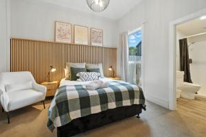 une chambre avec un lit et une chaise dans l'établissement Albemarle Villa, à Christchurch