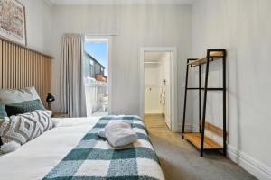 une chambre avec un lit avec une couverture rayée dans l'établissement Albemarle Villa, à Christchurch 6 autres photos