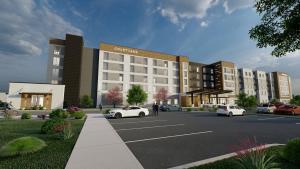 una rappresentazione di un edificio con auto parcheggiate in un parcheggio di Courtyard by Marriott Madison Huntsville a Madison