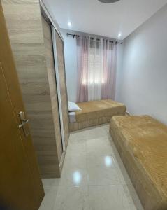 - une petite chambre avec 2 lits et une porte dans l'établissement tetouan, à Tetouan