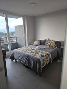 a bedroom with a bed and a large window at Alojamiento a pasos de Movistar Arenas, Universidad de Chile y Ministerio de Justicia in Santiago