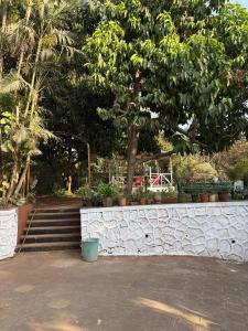 a stone retaining wall with a tree and stairs at Jasmine Villa in Thane best place to chill in Thane