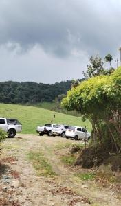 a group of cars parked on a dirt road at Las Bromelias in Coconuco +7 photos