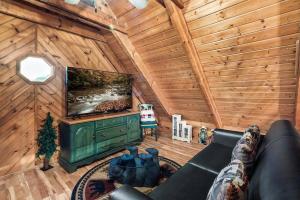 a living room with a couch and a tv in a cabin at Heavenly Views, Hot Tub, Short Drive to Fun in Sevierville