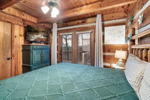 a bedroom with a blue bed and wooden walls at Heavenly Views, Hot Tub, Short Drive to Fun in Sevierville