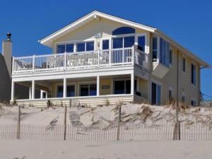 uma casa situada no topo de uma praia de areia em Ocean Front 1St Floor Duplex With Expansive Views In Brant Beach With Private Beach Access 12094 em Brant Beach