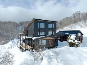 a house on top of a snowy hill in the snow at Kogane Hills Niseko in Rankoshi