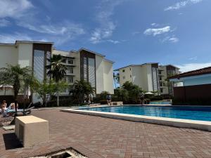 a swimming pool in front of some apartment buildings at Casa Bela in Parrita