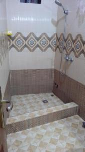 a shower in a bathroom with a tiled floor at La Belle Apartement 2x2 - Grand Mbao, plage in Dakar